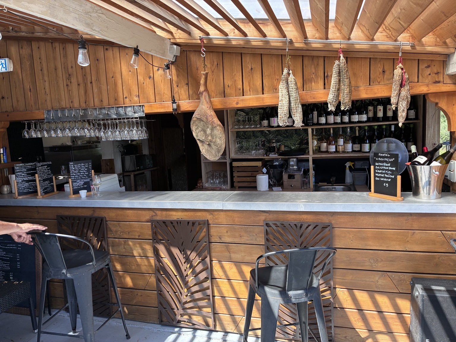 Bar en bois, vins et charcuteries suspendues